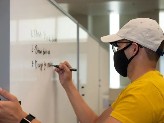 student writing on a whiteboard