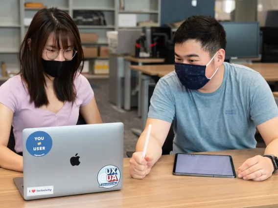 A man guides a woman on a usability test